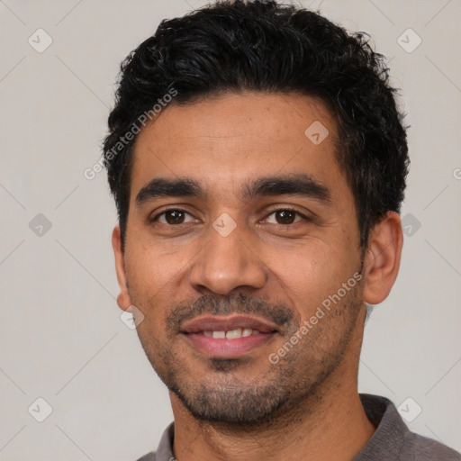 Joyful latino young-adult male with short  black hair and brown eyes