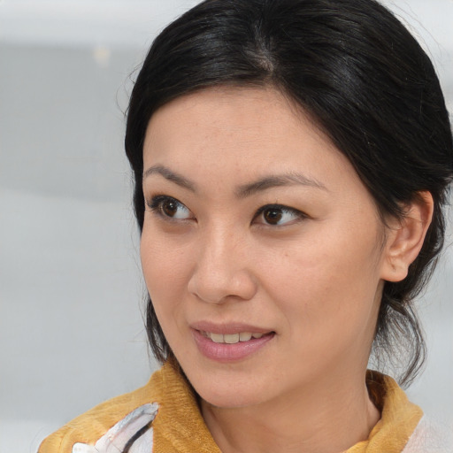 Joyful asian young-adult female with medium  brown hair and brown eyes