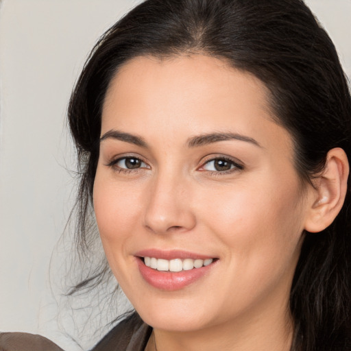 Joyful white young-adult female with long  brown hair and brown eyes