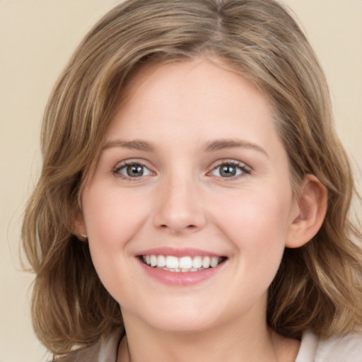 Joyful white young-adult female with medium  brown hair and green eyes