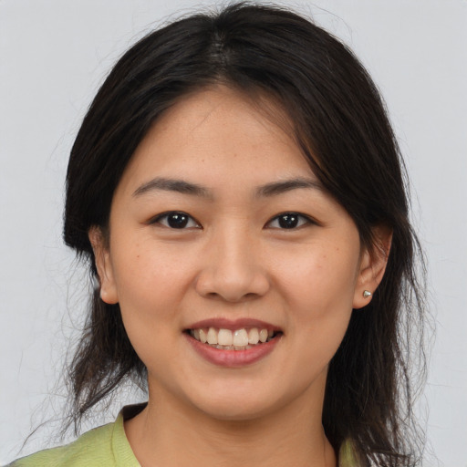 Joyful latino young-adult female with medium  brown hair and brown eyes