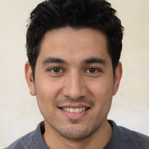 Joyful white young-adult male with short  black hair and brown eyes
