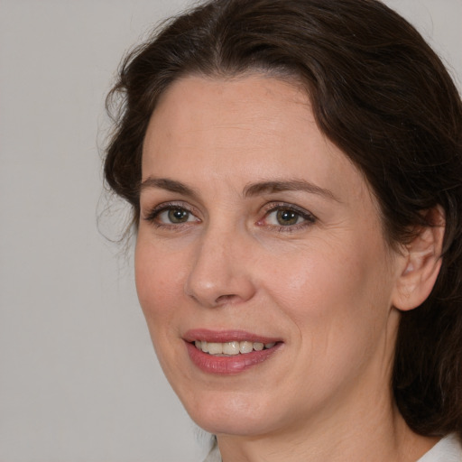 Joyful white adult female with medium  brown hair and brown eyes