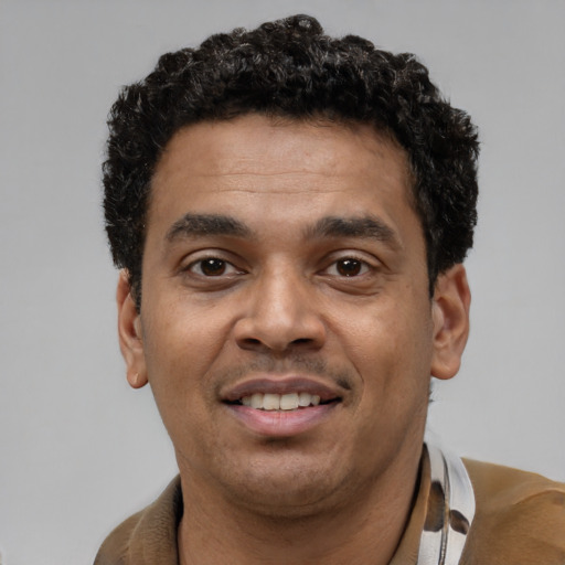 Joyful latino young-adult male with short  brown hair and brown eyes