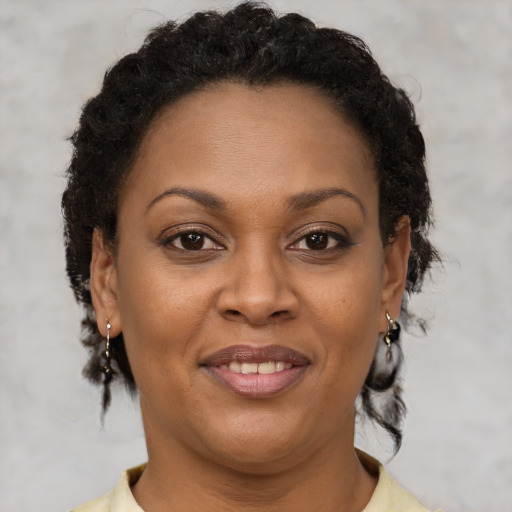 Joyful black adult female with short  brown hair and brown eyes