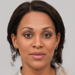 Joyful latino young-adult female with medium  brown hair and brown eyes