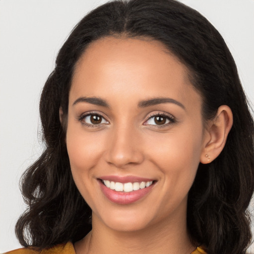 Joyful latino young-adult female with long  brown hair and brown eyes