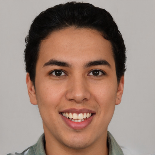 Joyful latino young-adult male with short  brown hair and brown eyes