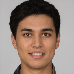 Joyful latino young-adult male with short  brown hair and brown eyes