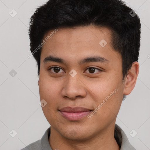 Joyful latino young-adult male with short  brown hair and brown eyes