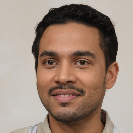 Joyful latino young-adult male with short  black hair and brown eyes