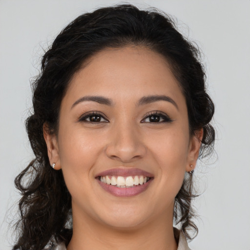 Joyful latino young-adult female with long  brown hair and brown eyes
