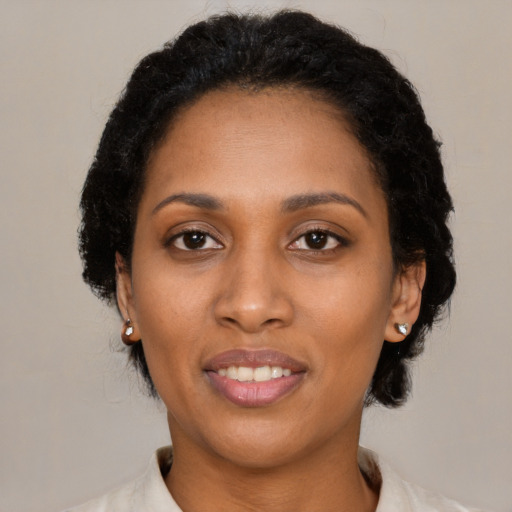 Joyful black young-adult female with medium  black hair and brown eyes