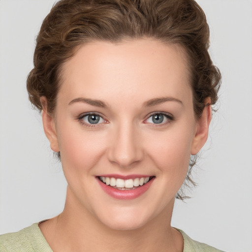 Joyful white young-adult female with short  brown hair and green eyes