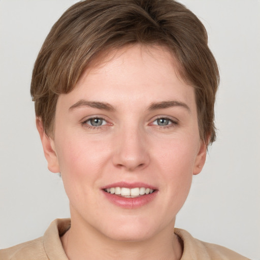 Joyful white young-adult female with short  brown hair and grey eyes