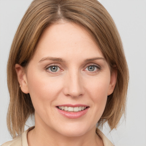 Joyful white young-adult female with medium  brown hair and grey eyes