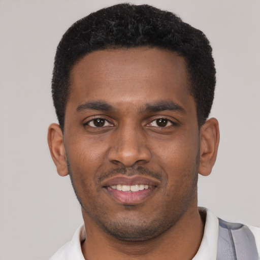 Joyful black young-adult male with short  black hair and brown eyes