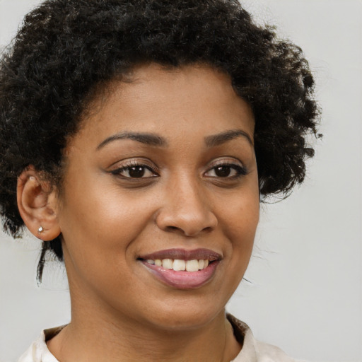 Joyful black young-adult female with short  brown hair and brown eyes