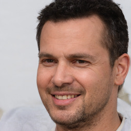 Joyful white adult male with short  brown hair and brown eyes