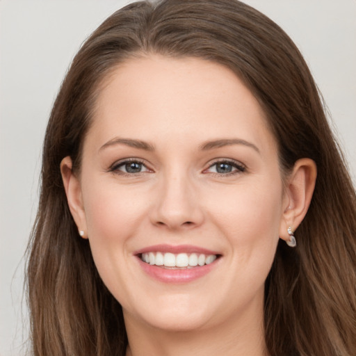 Joyful white young-adult female with long  brown hair and grey eyes