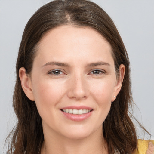 Joyful white young-adult female with long  brown hair and grey eyes