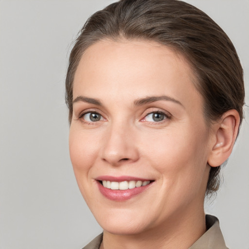 Joyful white young-adult female with medium  brown hair and grey eyes