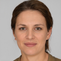 Joyful white adult female with medium  brown hair and grey eyes