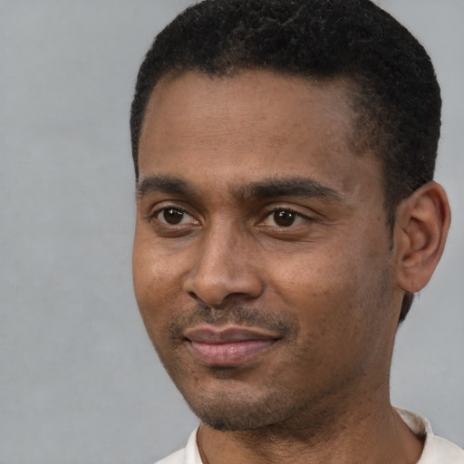 Joyful black young-adult male with short  black hair and brown eyes