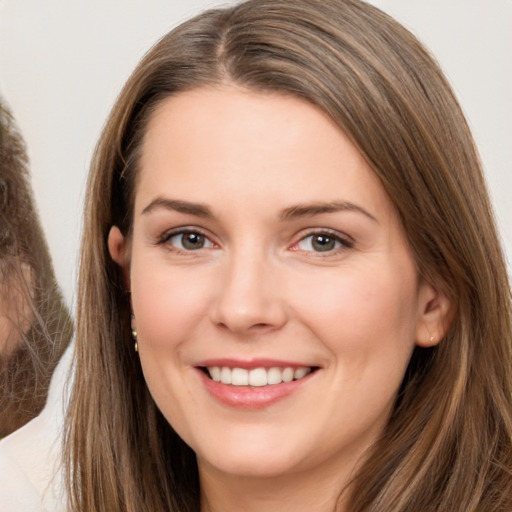 Joyful white young-adult female with long  brown hair and brown eyes