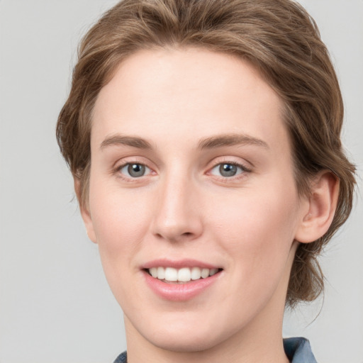 Joyful white young-adult female with medium  brown hair and blue eyes