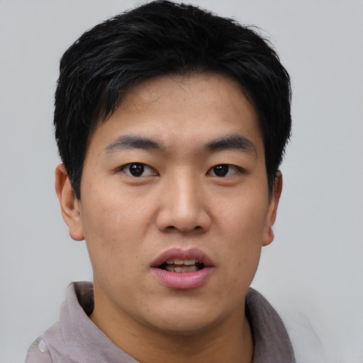 Joyful asian young-adult male with short  black hair and brown eyes