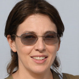 Joyful white young-adult female with medium  brown hair and blue eyes