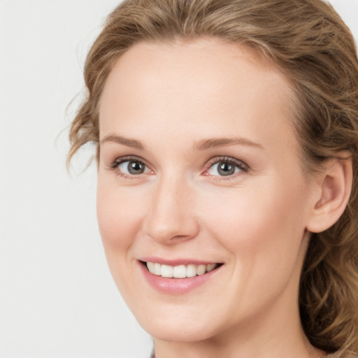 Joyful white young-adult female with medium  brown hair and blue eyes