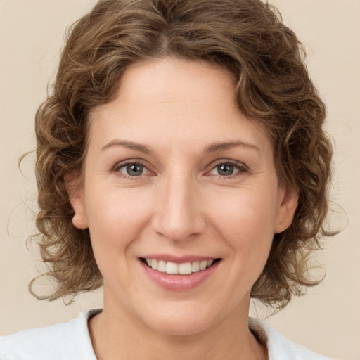 Joyful white young-adult female with medium  brown hair and green eyes