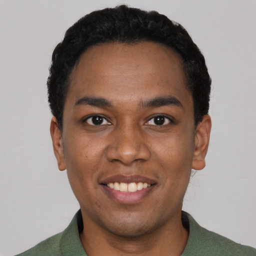 Joyful black young-adult male with short  black hair and brown eyes