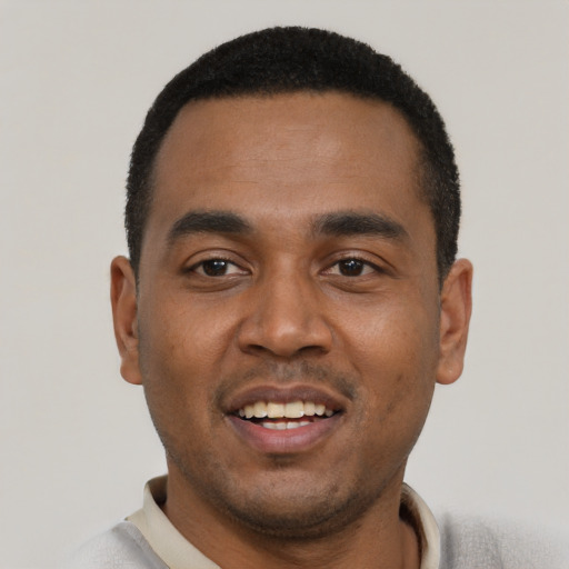 Joyful black young-adult male with short  black hair and brown eyes