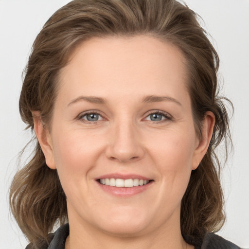 Joyful white young-adult female with medium  brown hair and grey eyes