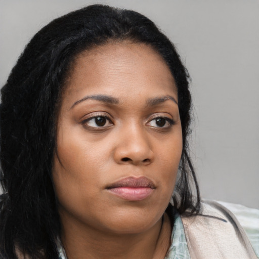 Joyful black young-adult female with long  brown hair and brown eyes