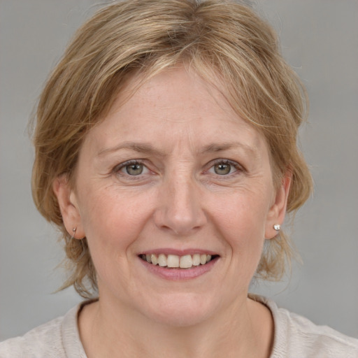 Joyful white adult female with medium  brown hair and blue eyes