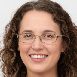 Joyful white adult female with long  brown hair and green eyes