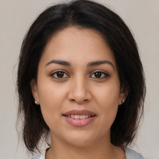 Joyful latino young-adult female with medium  brown hair and brown eyes