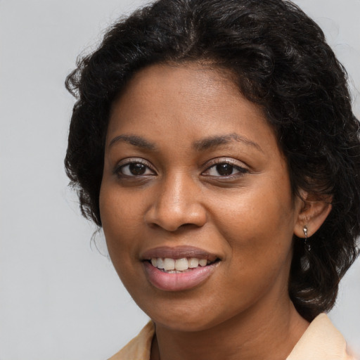 Joyful black young-adult female with long  brown hair and brown eyes