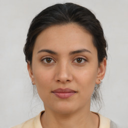 Joyful latino young-adult female with medium  brown hair and brown eyes