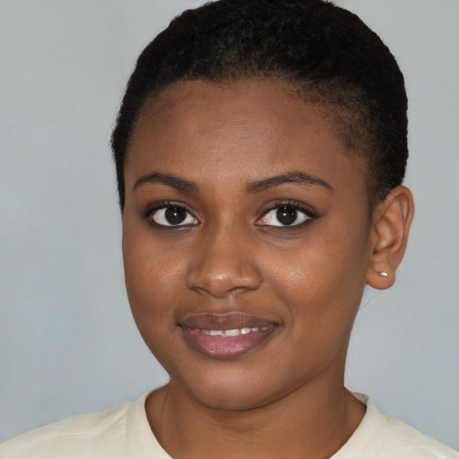 Joyful black young-adult female with short  brown hair and brown eyes