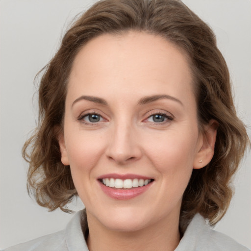 Joyful white young-adult female with medium  brown hair and green eyes