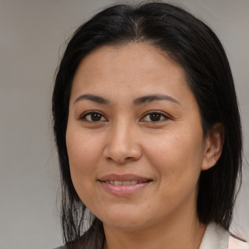Joyful latino young-adult female with medium  brown hair and brown eyes