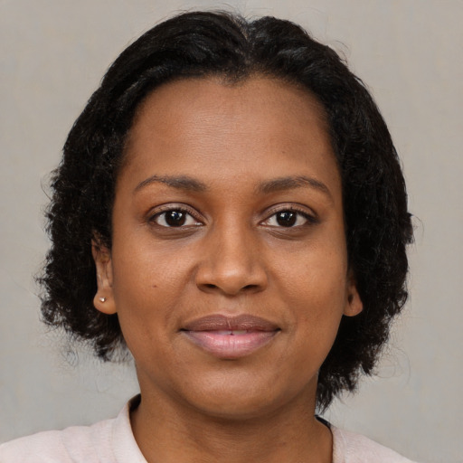 Joyful black young-adult female with medium  brown hair and brown eyes