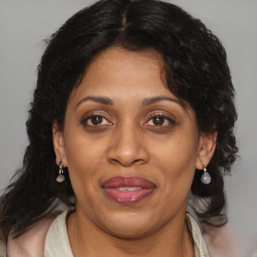 Joyful latino adult female with medium  brown hair and brown eyes