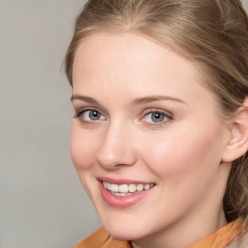 Joyful white young-adult female with medium  brown hair and blue eyes