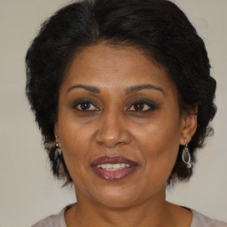 Joyful black adult female with medium  brown hair and brown eyes